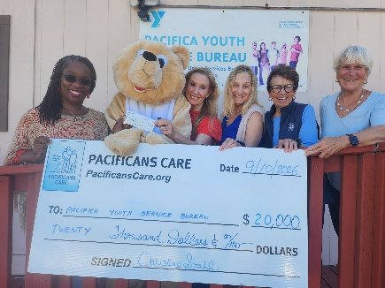 Pacifica Youth Service Bureau staff and the bear mascot holding a $20,000 Pacificans Care check
